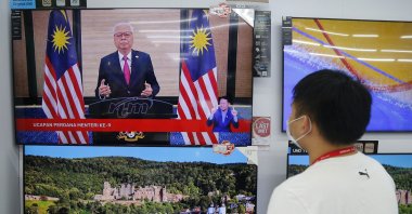 An electronic shop worker watches a speech by Malaysia's new Prime Minister Ismail Sabri Yaakob on television in Shah Alam, Malaysia, Aug. 22, 2021. (AP Photo)