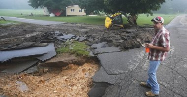 Michael Pate watches as a road is repaired in McEwen, Tenn., U.S., Aug. 22, 2021. (AP Photo)