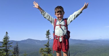 5-year-old Harvey Sutton raises his arms on a mountain top in Bigelow Preserve while hiking the Appalachian Trail, Maine, U.S., July 23, 2021. (AP Photo)
