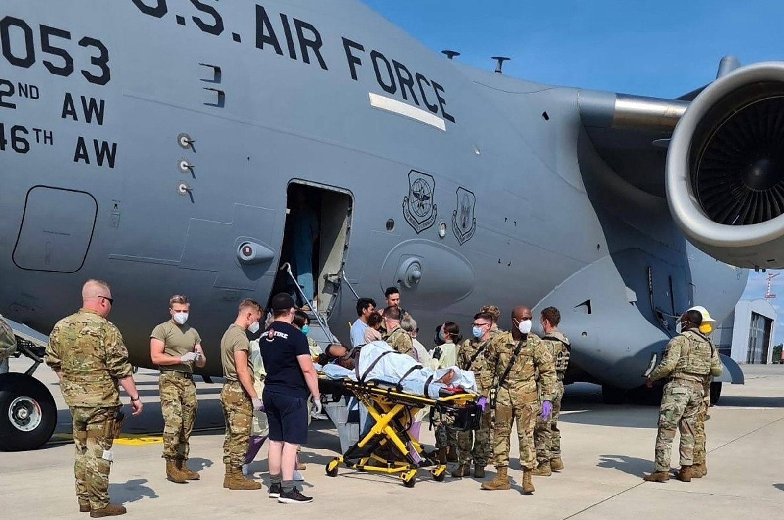 Medical support personnel from the 86th Medical Group help an Afghan mother and family off a U.S. Air Force C-17 moments after she delivered a baby aboard the aircraft after landing at Ramstein Air Base, Germany, Aug. 21, 2021. (AFP Photo)