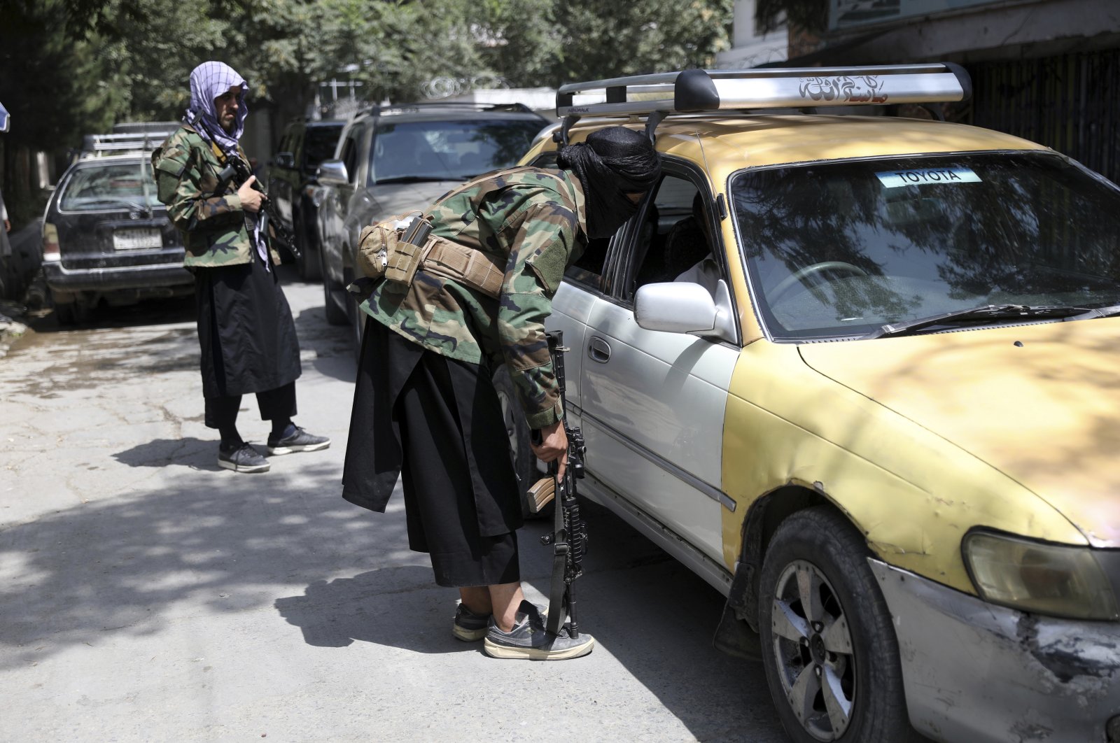 Taliban fighters search a vehicle at a checkpoint on the road in the Wazir Akbar Khan neighborhood in the city of Kabul, Afghanistan, Sunday, Aug. 22, 2021. (AP Photo)
