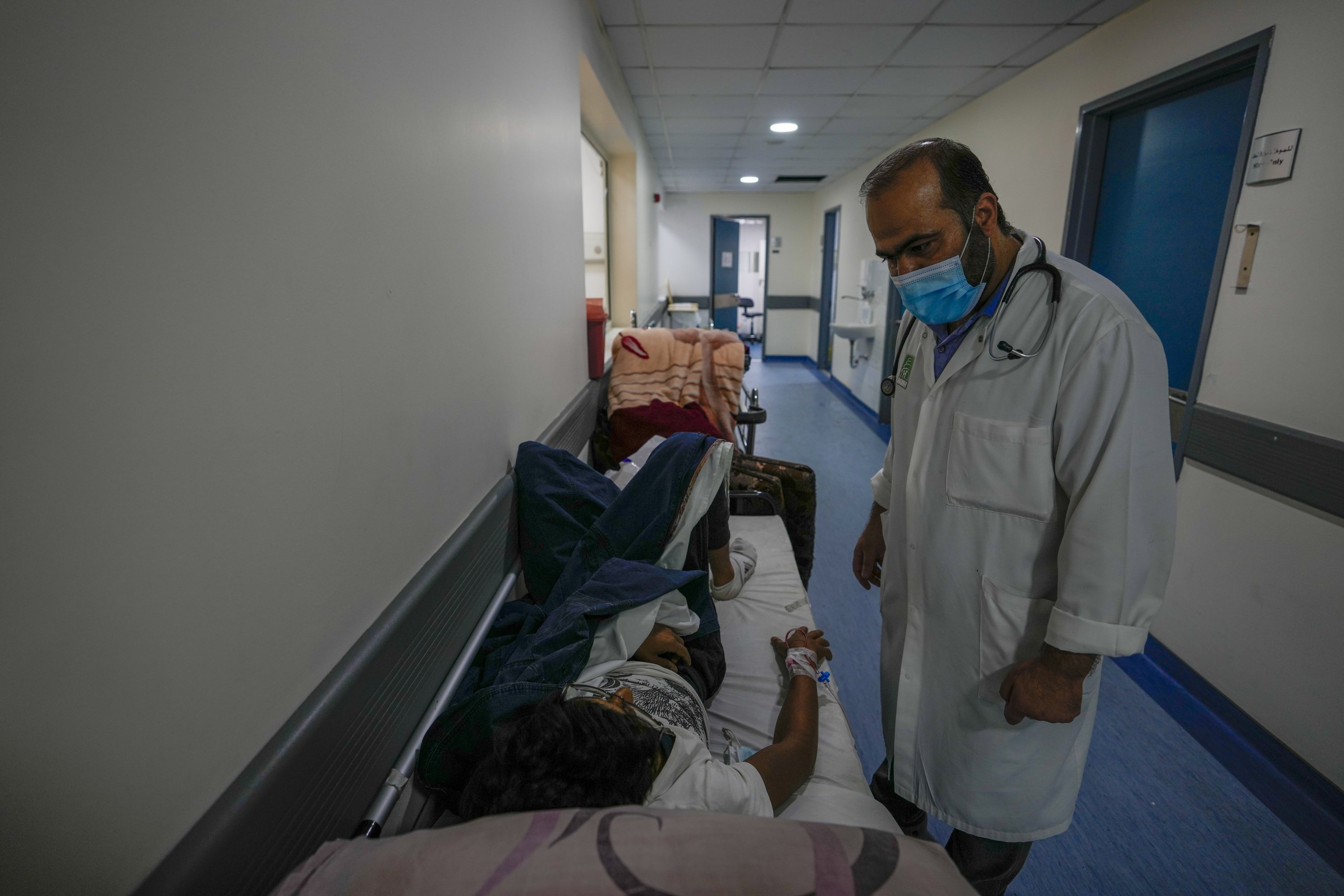 Doctor Jihad Bikai checks on a patient in a bed at the crowded government-run Rafik Hariri University Hospital in Beirut, Lebanon, Aug. 11, 2021. (AP Photo)