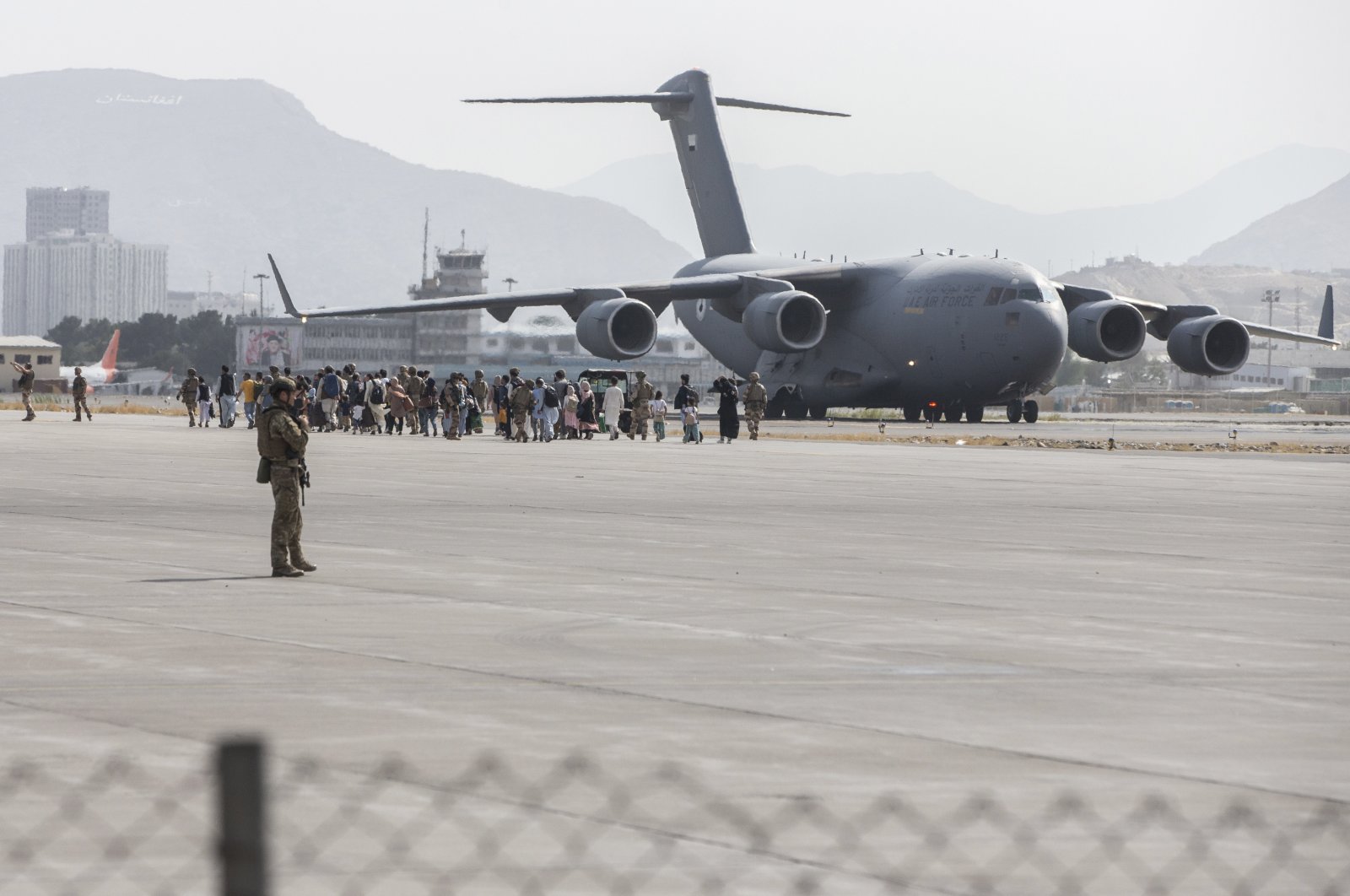 In this photo provided by the U.S. Marine Corps, evacuees load onto a U.S. Air Force Boeing C-17 Globemaster III during an evacuation at Kabul Hamid Karzai International Airport, Kabul, Afghanistan, Aug. 21, 2021. (Sgt. Samuel Ruiz/U.S. Marine Corps via AP)
