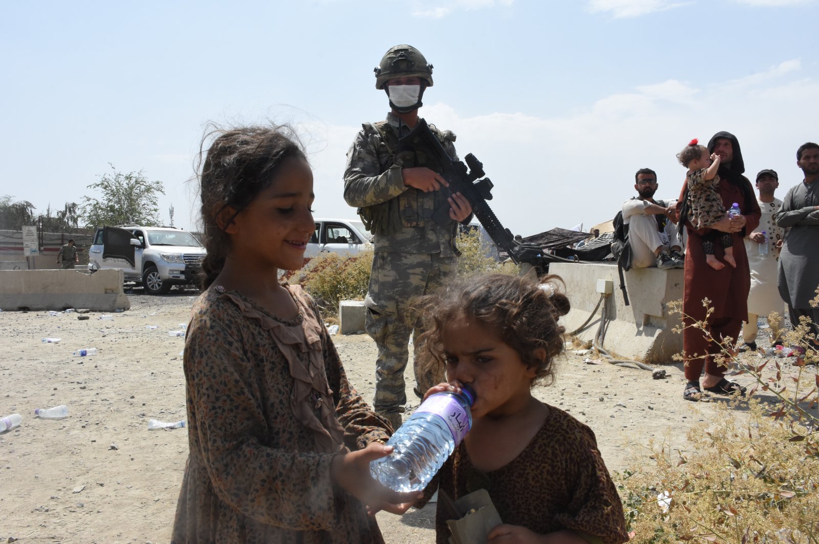 Afghan children drink water provided by Turkish soldiers near Kabul Hamid Karzai International Airport, Afghanistan, Aug. 22, 2021. (AA Photo)