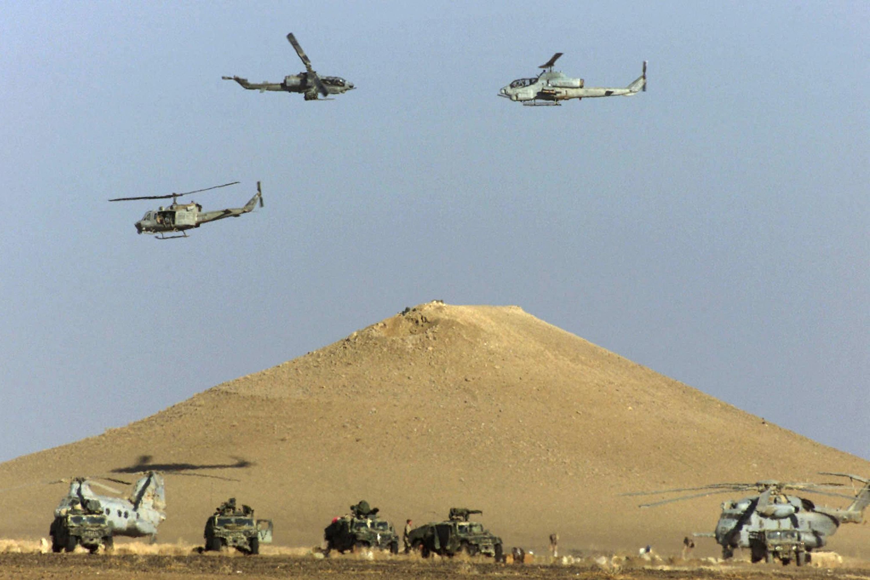 U.S. Marine Cobra attack helicopters circling above larger CH-53 helicopters at the U.S. Marines operations base in southern Afghanistan before heading out north on a mission, Dec. 4, 2001. (AFP Photo)