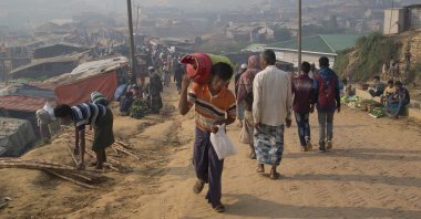 A Rohingya refugee walks carrying a cooking gas cylinder inside Balukhali refugee camp near Cox's Bazar in Bangladesh, Nov. 17, 2018. (AP Photo)