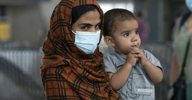 Families evacuated from Kabul, Afghanistan, walk through the terminal before boarding a bus after they arrived at Washington Dulles International Airport, in Chantilly, Virginia, U.S., Aug. 23, 2021. (AP Photo)