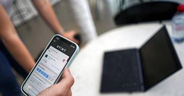 Co-founder of the app Stint, Sol Schlagman, holds his smartphone displaying the app running, at their headquarters in Camden, London, U.K., Aug. 23, 2021. (AP Photo)