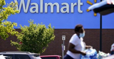A shopper loads items into her car in the parking lot of a Walmart in Willow Grove, Pennsylvania, U.S., May 19, 2021. (AP Photo)
