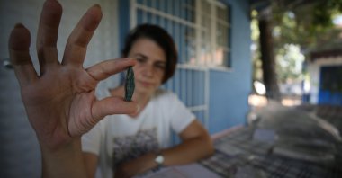 An archaeologist shows an arrowhead found in the ancient city of Daskyleion, Balıkesir, western Turkey, Aug. 23, 2021. (AA Photo)