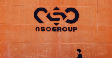 A man walks past the logo of Israeli cyber firm NSO Group at one of its branches in the Arava Desert, southern Israel, July 22, 2021. (Reuters Photo)