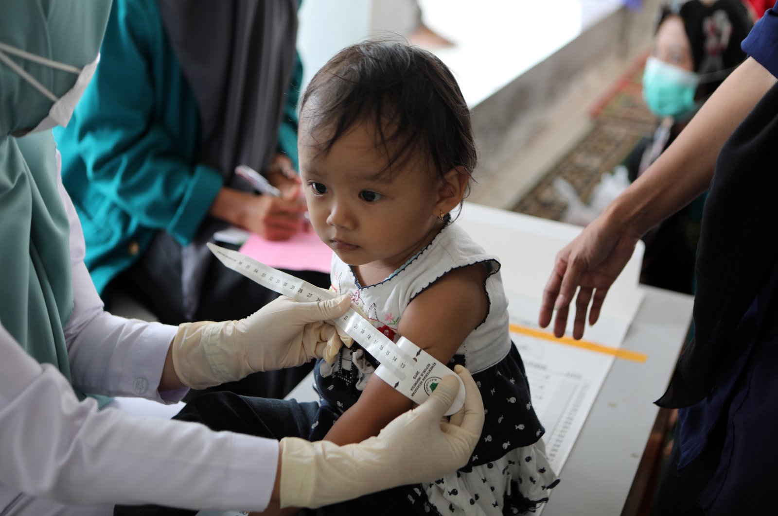 A nurse measures a child at The Children Community Health Care in Ulee Kareng, Banda Aceh, Indonesia, 24 August 2021. (EPA Photo) 
