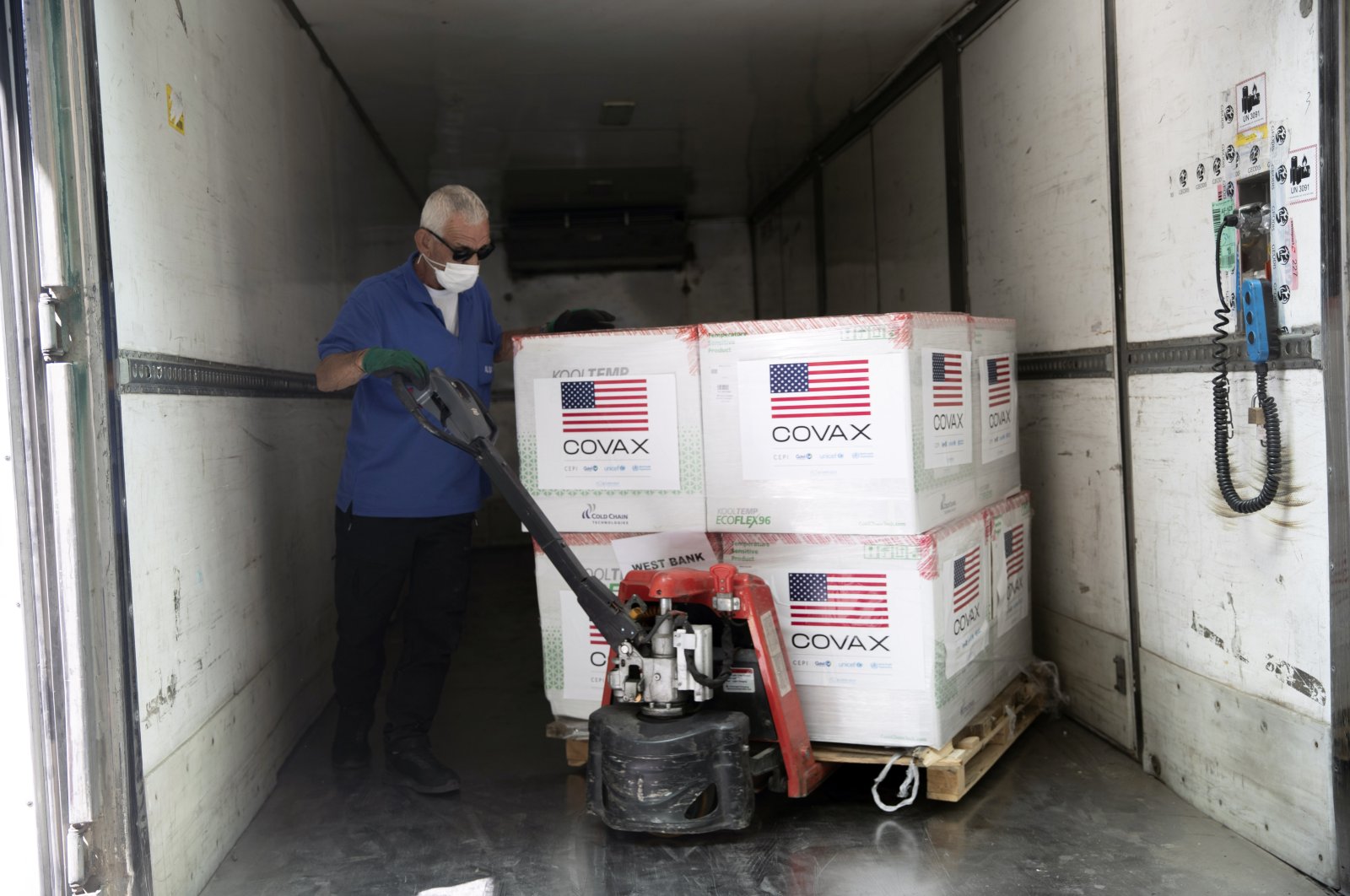 Palestinians unload a shipment of the Moderna coronavirus vaccine donated by the U.S, at the Palestinian health ministry, in the West Bank village of Salem, near Nablus, Aug. 24, 2021. (AP Photo)