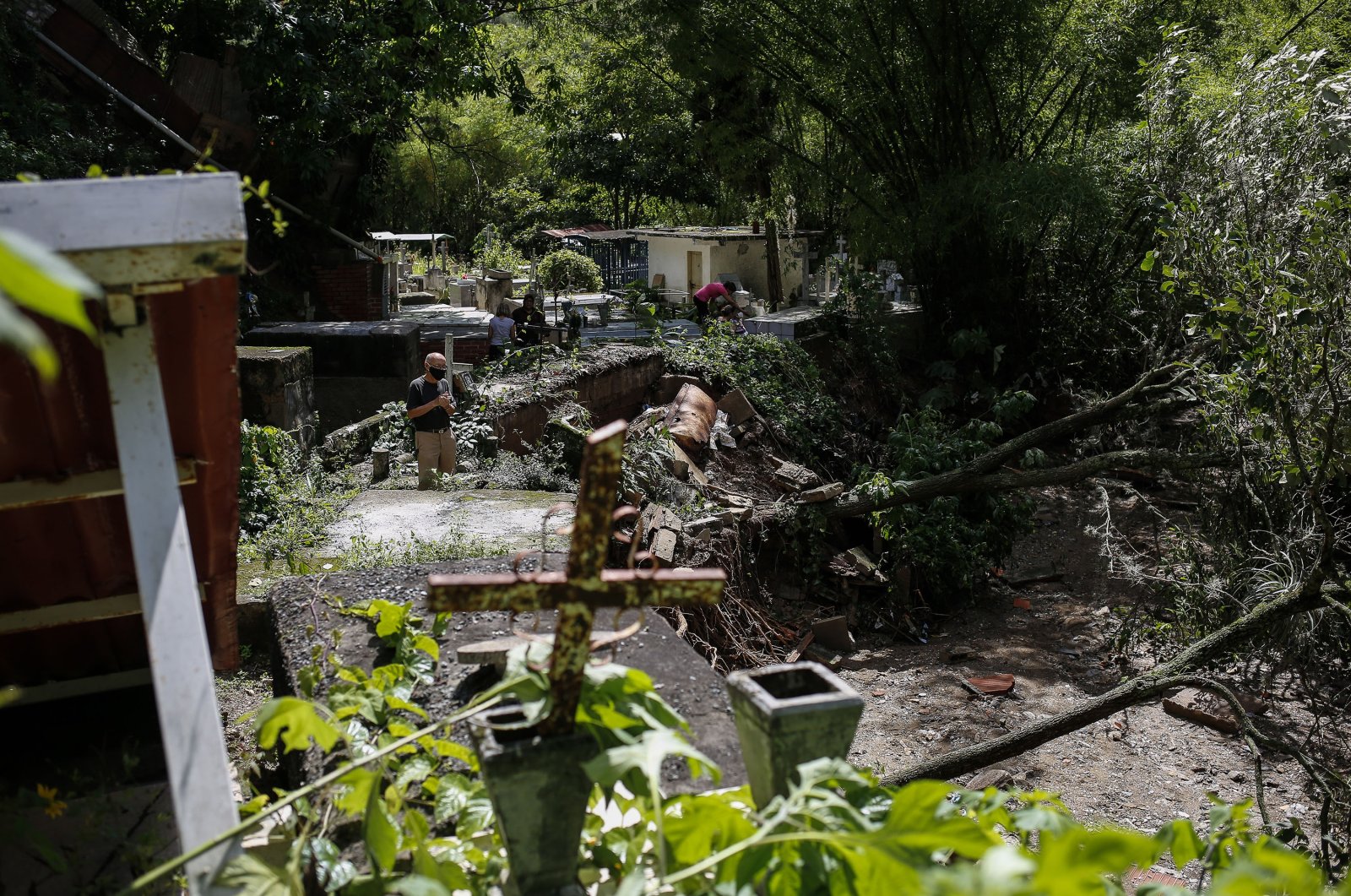 A man watches the damage at a public cemetery after heavy rain caused flooding the previous day in Los Angelinos Canyon, Venezuela, June 25, 2021. (Getty Images)