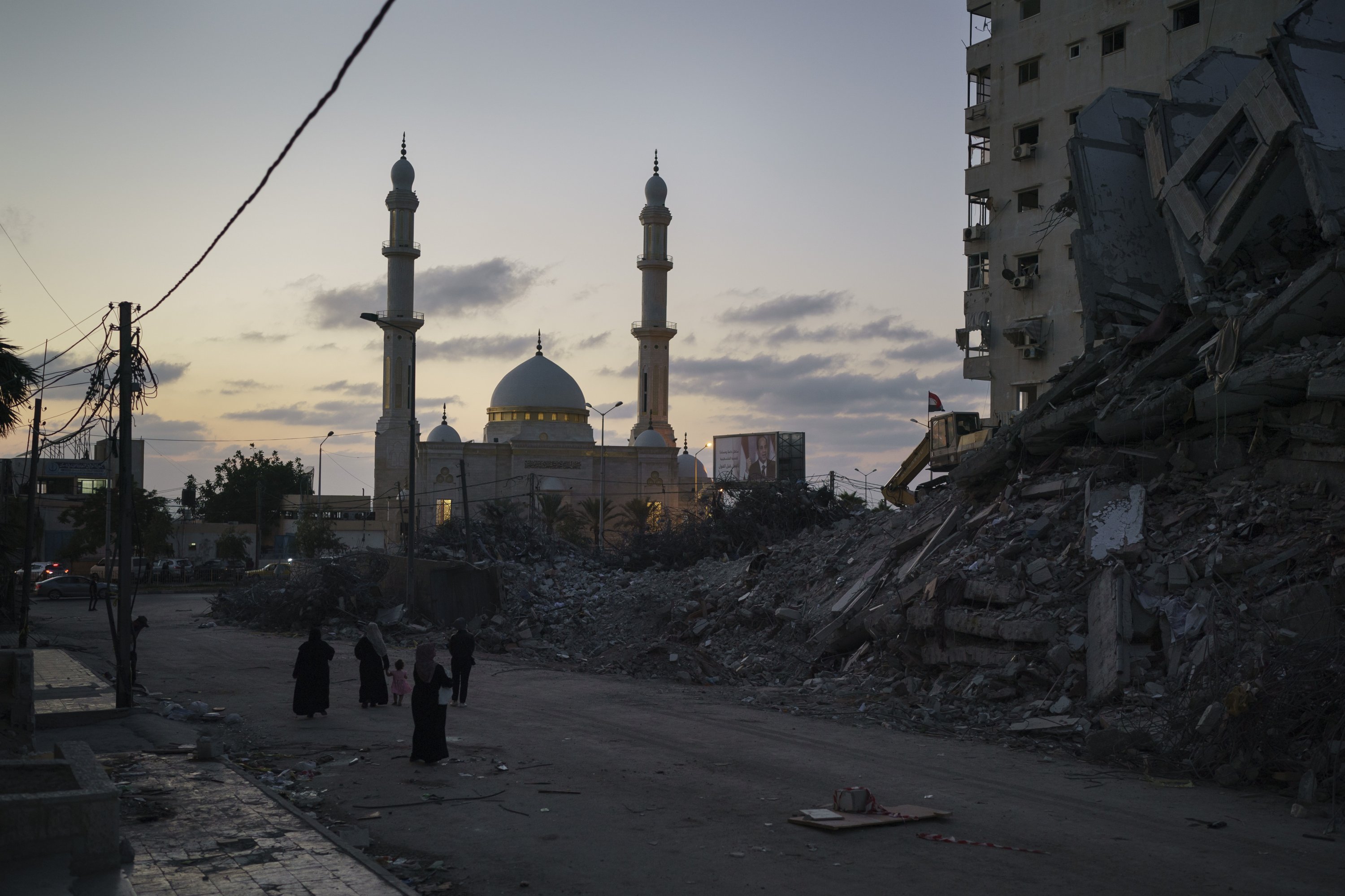 Palestinians walk next to the rubble of a building destroyed by an airstrike during an 11-day war between Israel and Hamas in Gaza City, Palestine, June 10, 2021. (AP Photo)