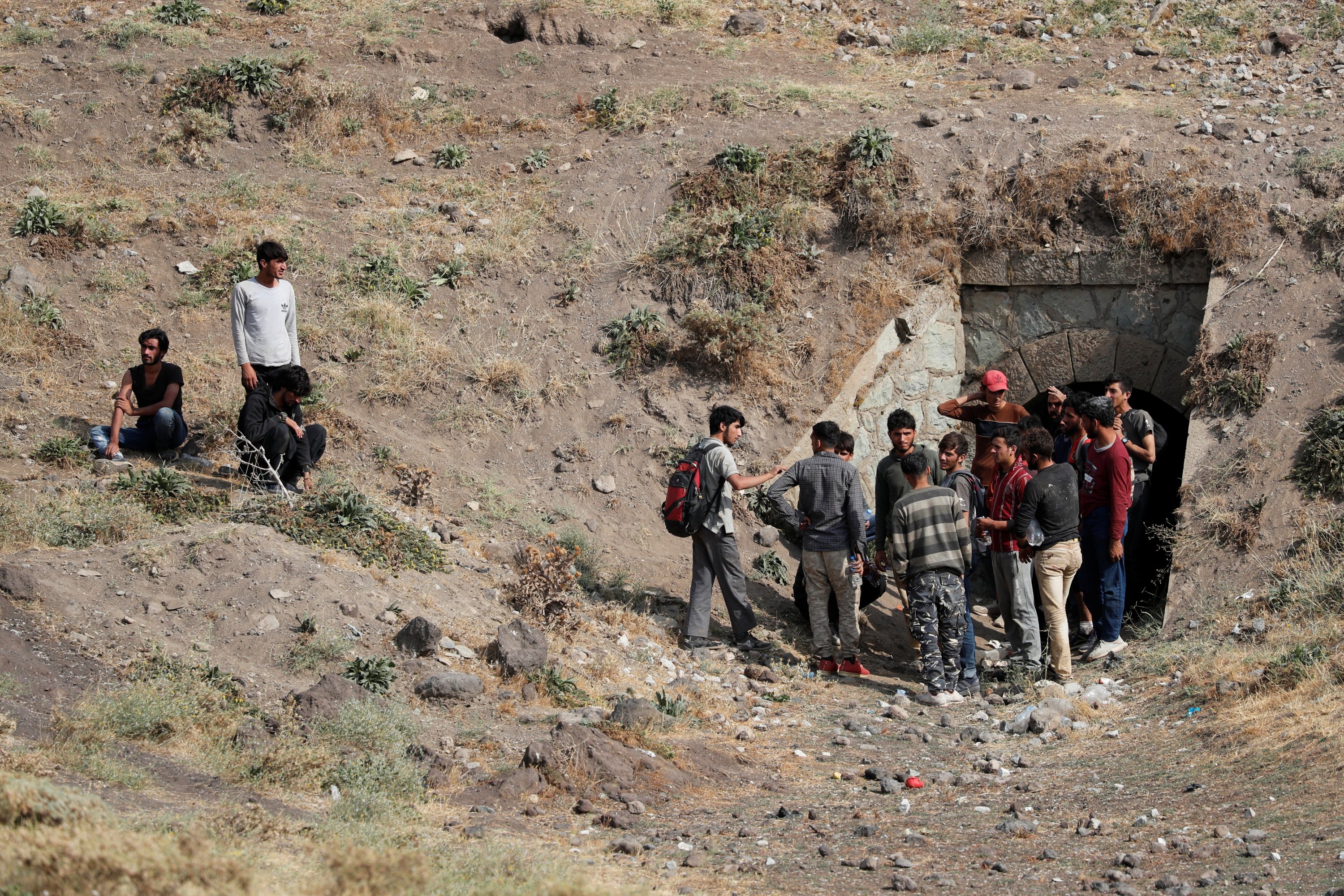 Afghan migrants stand outside a tunnel under train tracks after crossing illegally into Turkey from Iran, as they hide from security forces near Tatvan in Bitlis province, Turkey, Aug. 23, 2021. (Reuters Photo)