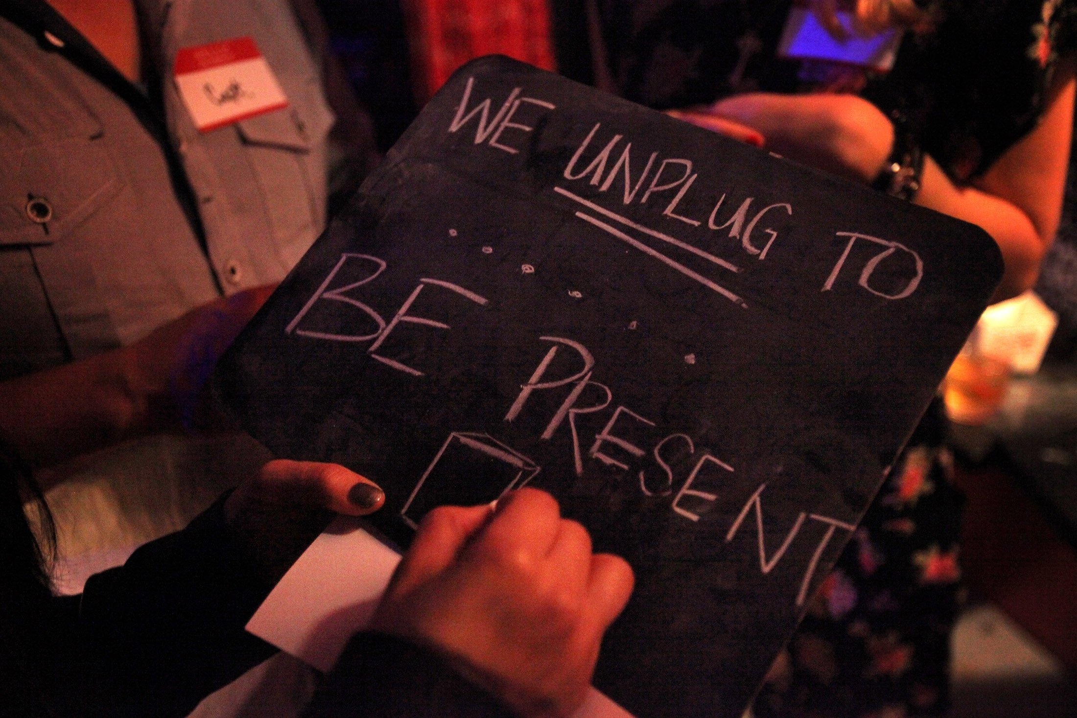 An attendant makes a sign that says “We unplug to be present,” at the Unplug SF event at Broadway Studios in North Beach in San Francisco, California, U.S., March 7, 2014. (Getty Images)