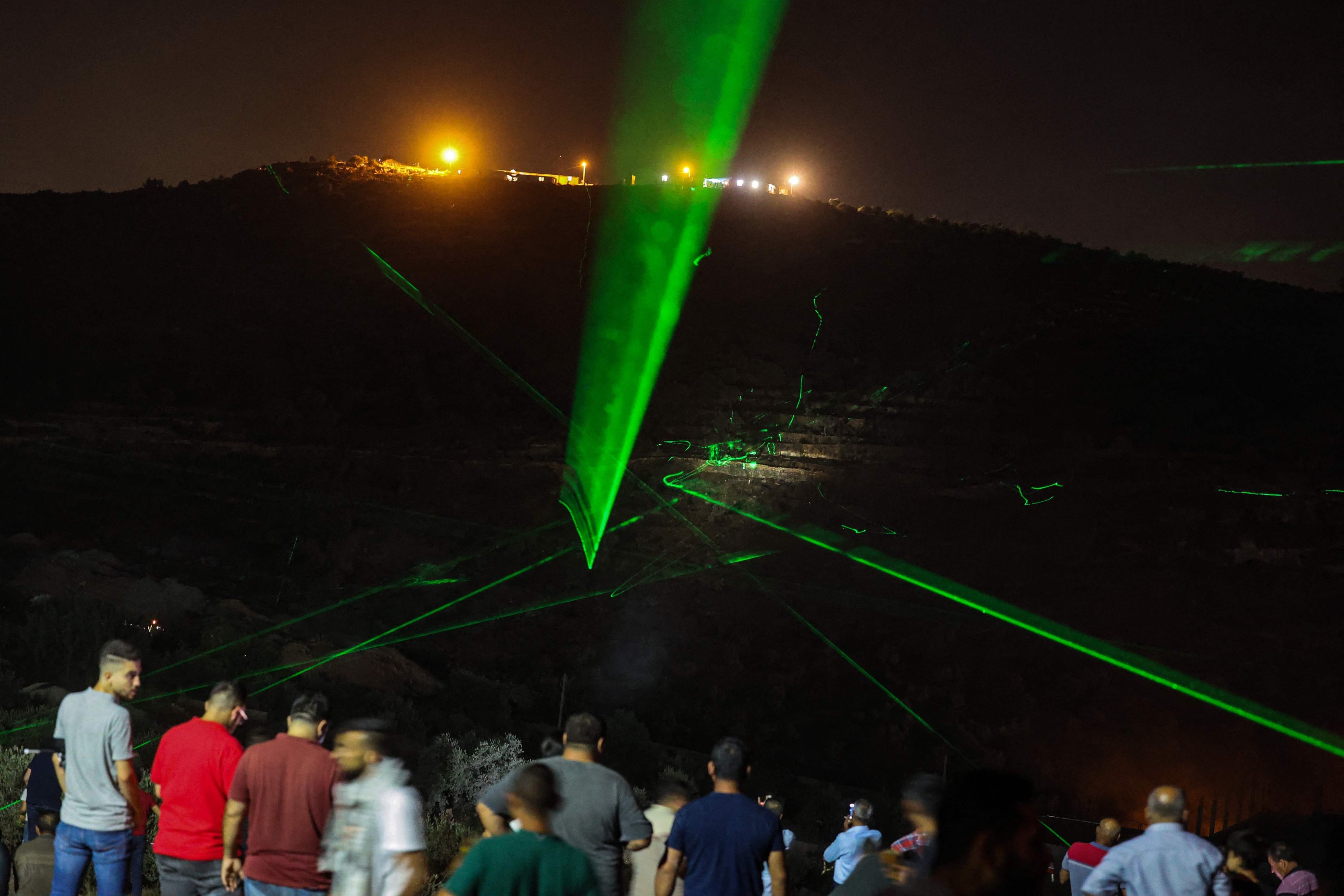 Palestinian protesters use laser torches during a demonstration against the Israeli settlers