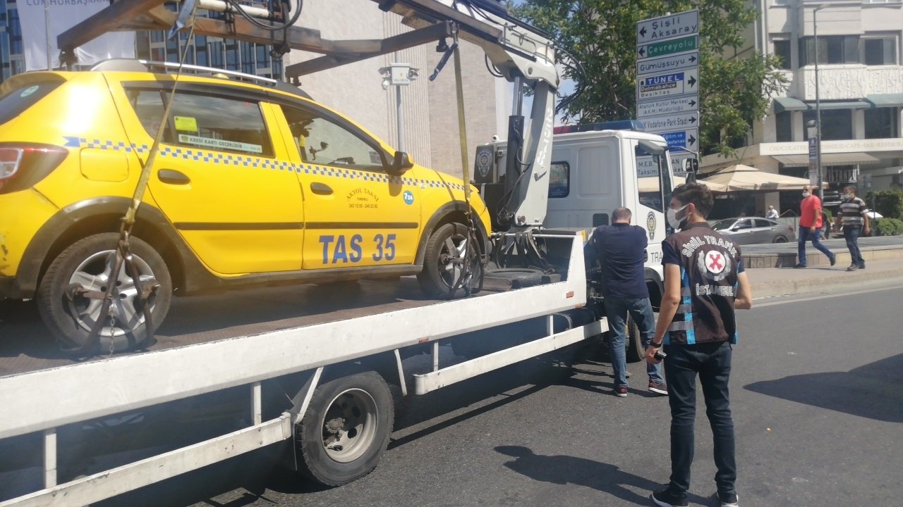 Police tow away a taxi whose driver was fined for overcharging tourists, in Istanbul, Turkey, Aug. 24, 2021. (PHOTO BY YUNUS EMRE KAVAK) 