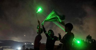 Young Palestinian protesters use laser torches during a demonstration against the Israeli settlers' outpost of Eviatar, in the town of Beita, occupied West Bank, Palestine, July 13, 2021. (AFP Photo)