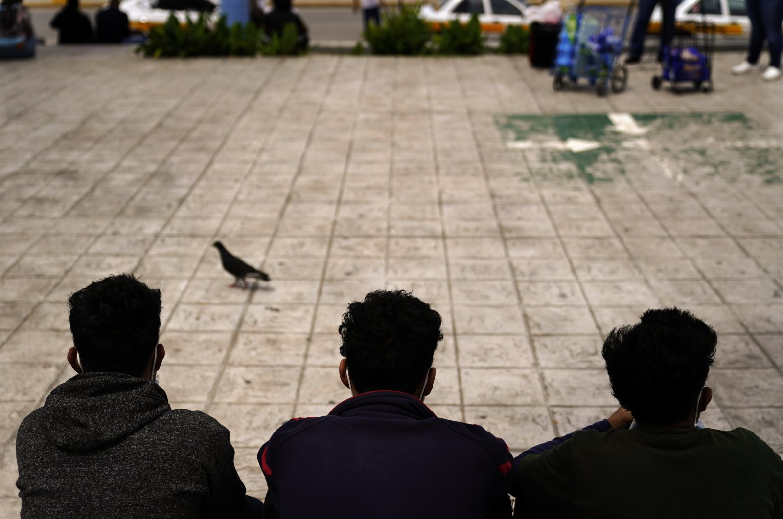 Honduran migrants sit in a plaza at the border after being returned from the U.S. to Mexico, in Reynosa, Mexico, May 13, 2021. (AP Photo)
