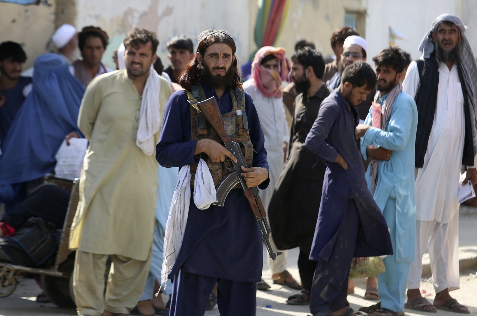A Taliban fighter stands guard on Afghan side while people wait to cross at a border crossing point between Pakistan and Afghanistan, in Torkham, in Khyber district, Pakistan, Aug. 21, 2021. (AP Photo)