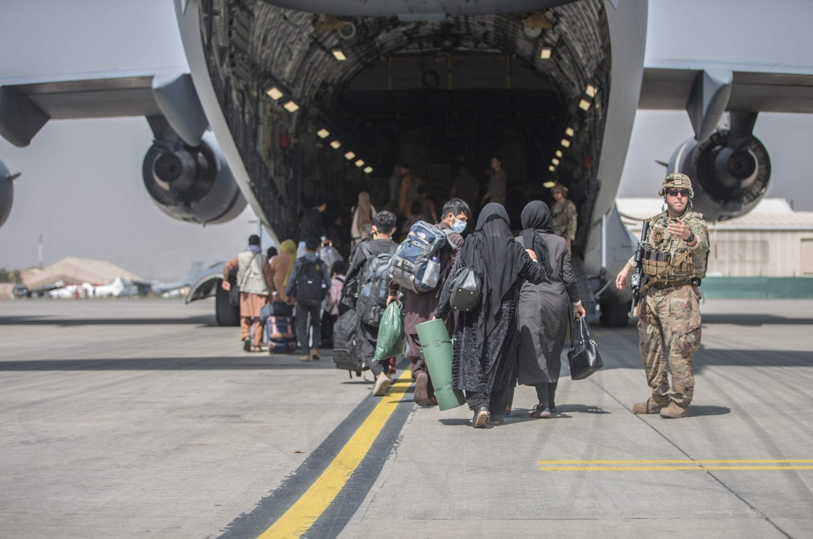 Families begin to board a U.S. Air Force Boeing C-17 Globemaster III during an evacuation at Kabul Hamid Karzai International Airport, Kabul, Afghanistan, Aug. 23, 2021. (U.S. Marine Corps via AFP Photo)