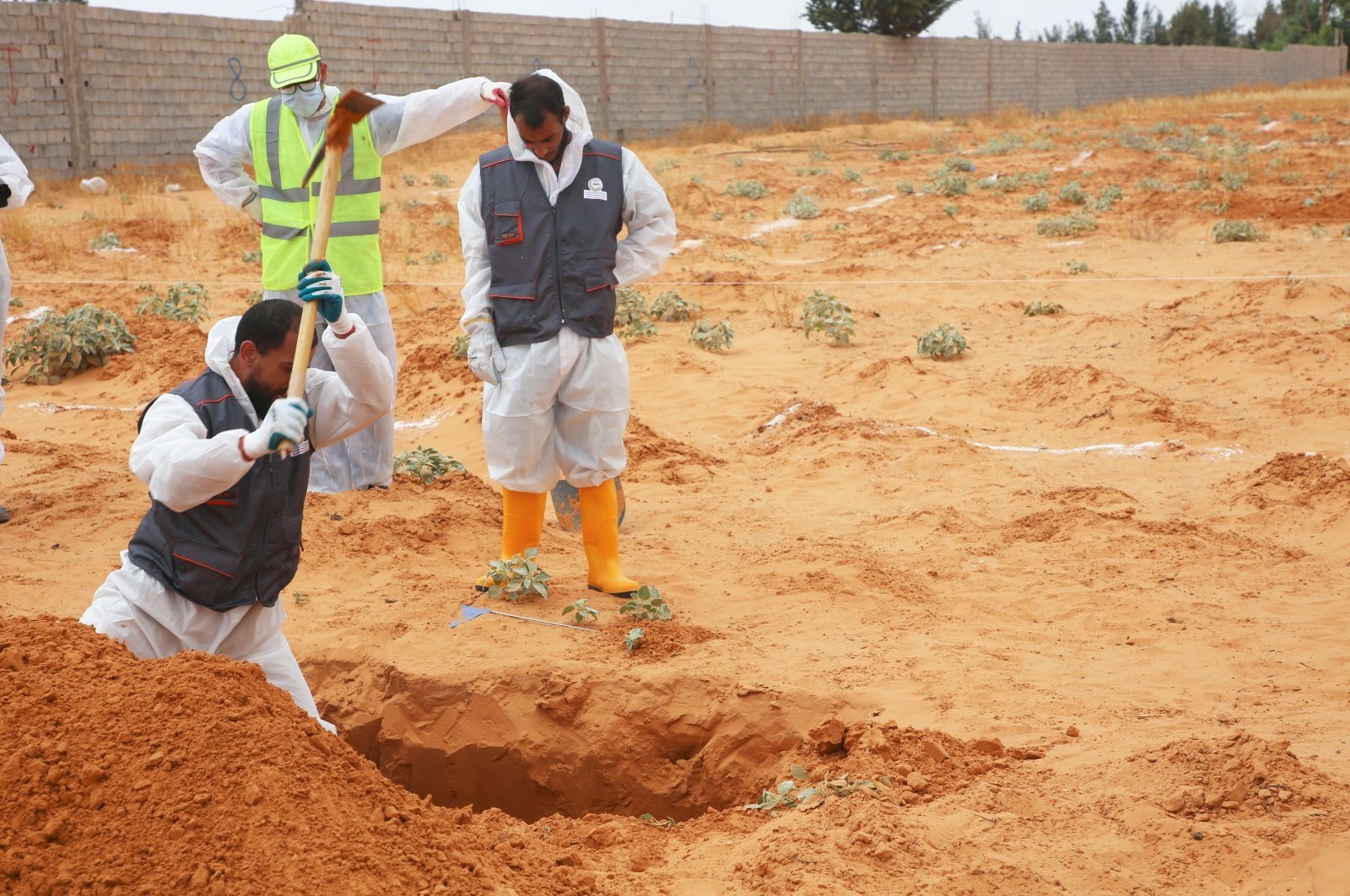 Libyan Ministry of Justice employees dig out at a site of a suspected mass grave in the town of Tarhouna, Libya, Tuesday, June 23, 2020. (AP Photo)