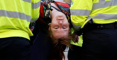 Police officers carry a climate activist from Extinction Rebellion during the group's "Impossible Rebellion" series of actions at Oxford Circus in central London, U.K., on Aug. 25, 2021. (AFP Photo)
