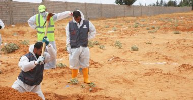 Libyan Ministry of Justice employees dig out at a site of a suspected mass grave in the town of Tarhouna, Libya, Tuesday, June 23, 2020. (AP Photo)