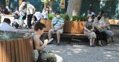 A woman checks her tablet computer at a park in Çankaya district, in the capital Ankara, Turkey, Aug. 26, 2021. (IHA Photo)