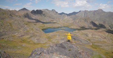 A person stands at the edge of a cliff in the Yedigöller region in the Ispir district of Erzurum, Turkey, Aug. 26, 2021. (AA Photo)