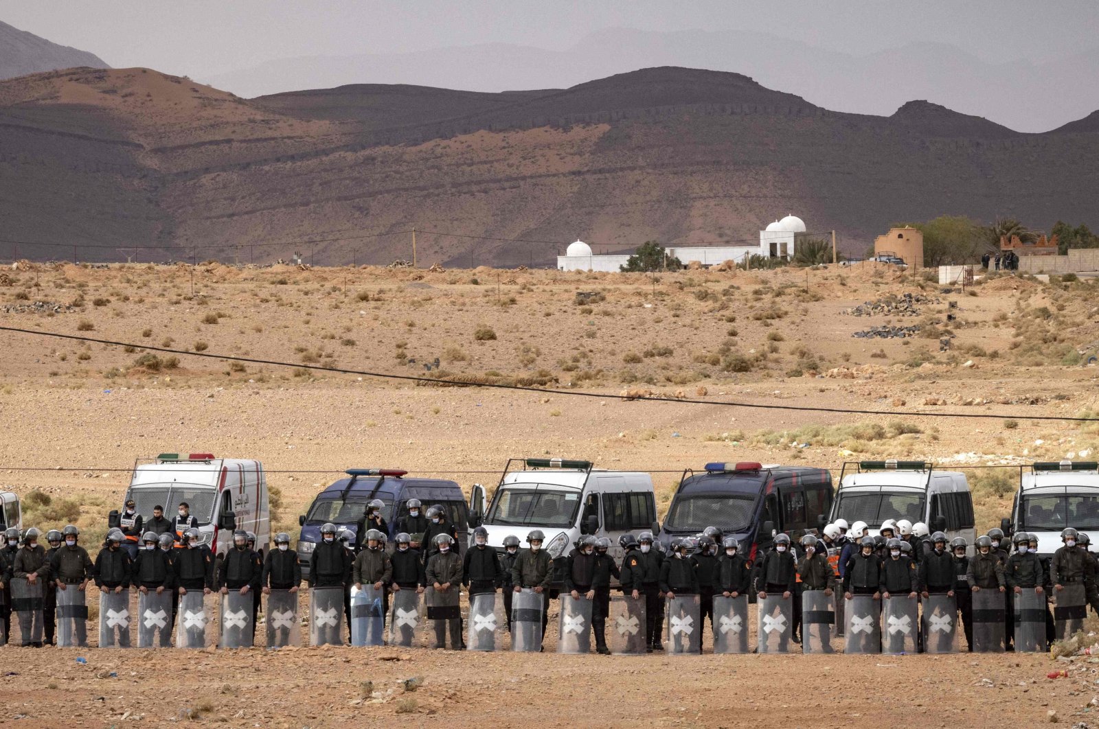 Moroccan security forces stand guard as Moroccan farmers protest in the city of Figuig after Algerian authorities expelled date growers from the Algerian territory, a border area they are traditionally authorized to farm, March 18, 2021. (AFP Photo)