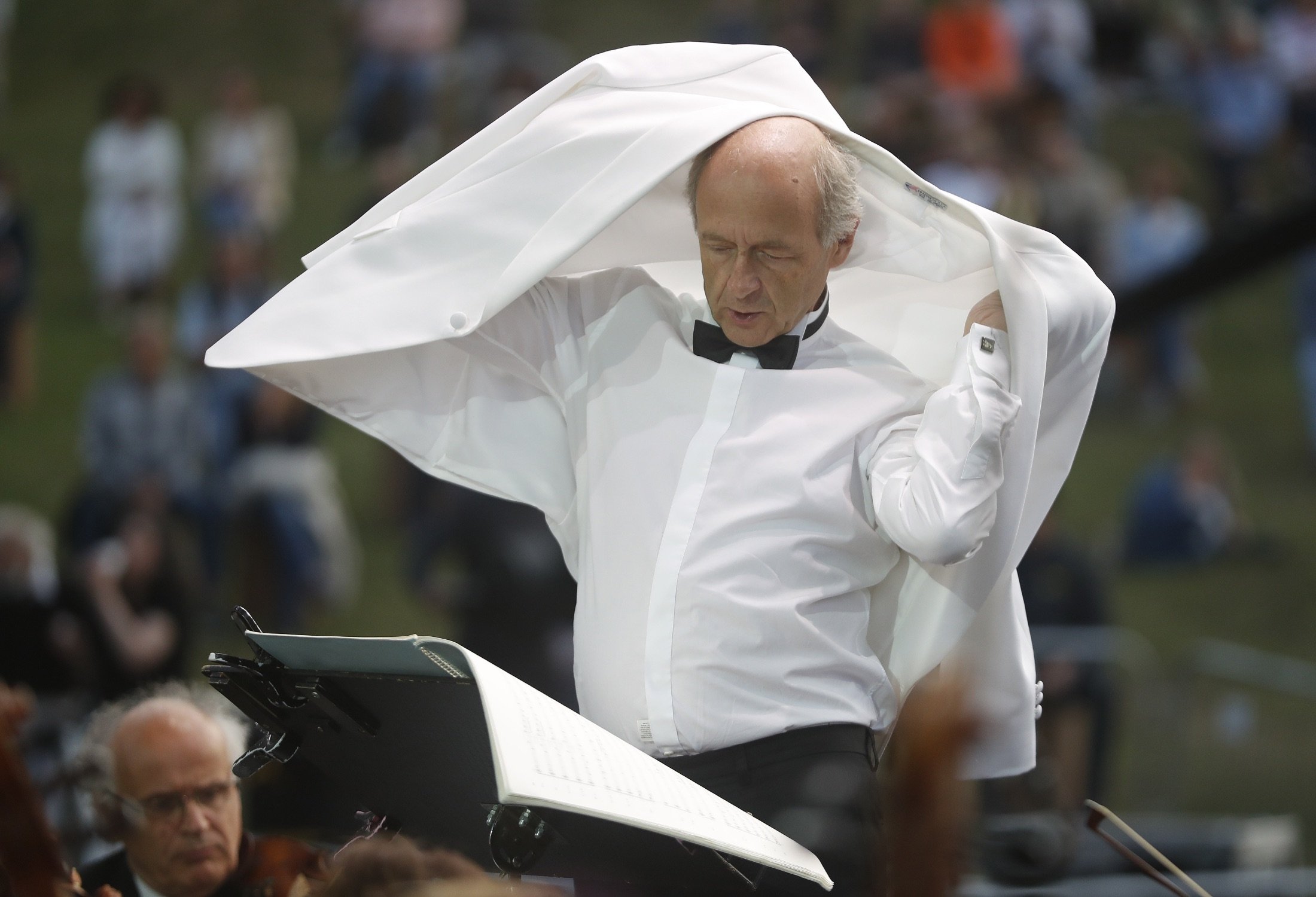 Ivan Fischer, the founder of the Budapest Festival Orchestra, adjusts his jacket after receiving his third dose of the COVID-19 vaccine during their free concert in Budapest, Hungary, Aug. 25, 2021. (AP Photo)
