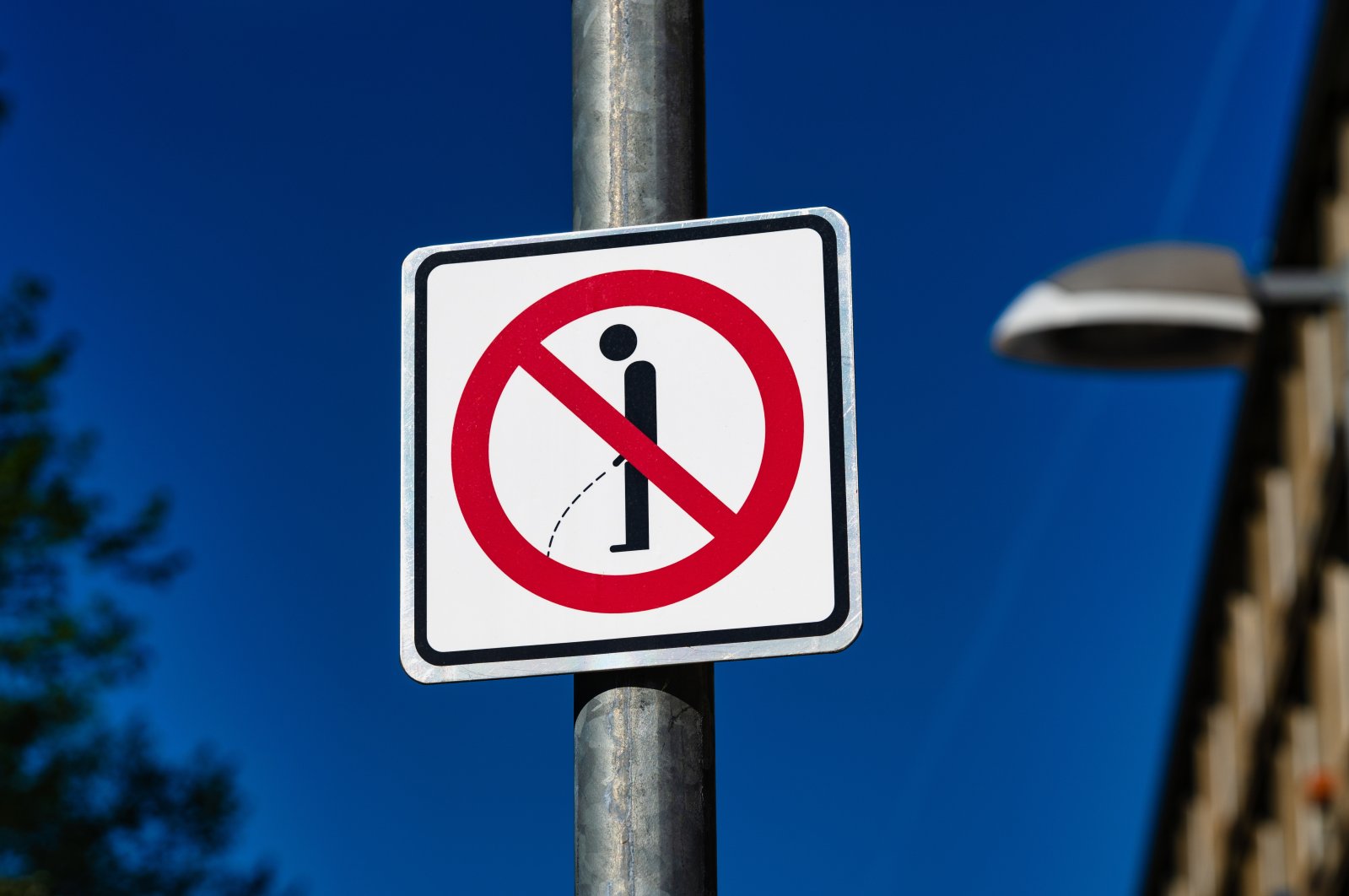A sign reminding passersby to not pee in public.