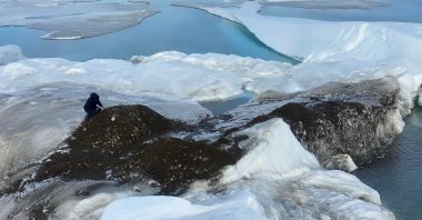 An undated handout image of Henrik Lassen, chief logistician for the Leister Expedition, which discovered a tiny island off the coast of Greenland which they say is the world's northernmost point of land, in the process of collecting samples for later scientific analysis. (Julian Charriere via REUTERS)