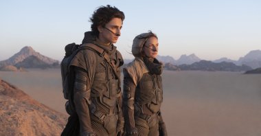 Timothee Chalamet (L), and Rebecca Ferguson look off into the distance, in a scene from the film "Dune." (Warner Bros. via AP)