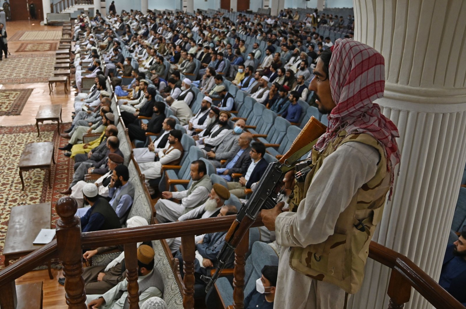 A Taliban fighter stands guard as acting Higher Education Minister Abdul Baqi Haqqani addresses a gathering during a consultative meeting on Taliban's general higher education policies at the Loya Jirga Hall in Kabu, Afghanistan, on Aug. 29, 2021. (Aamir QURESHI / AFP)