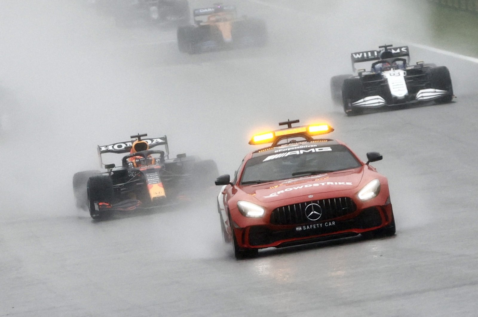 A Formula One safety car leads race drivers as the start of the Belgian Grand Prix is delayed due to bad weather at Spa, Belgium, Aug. 29, 2021. (Reuters Photo)