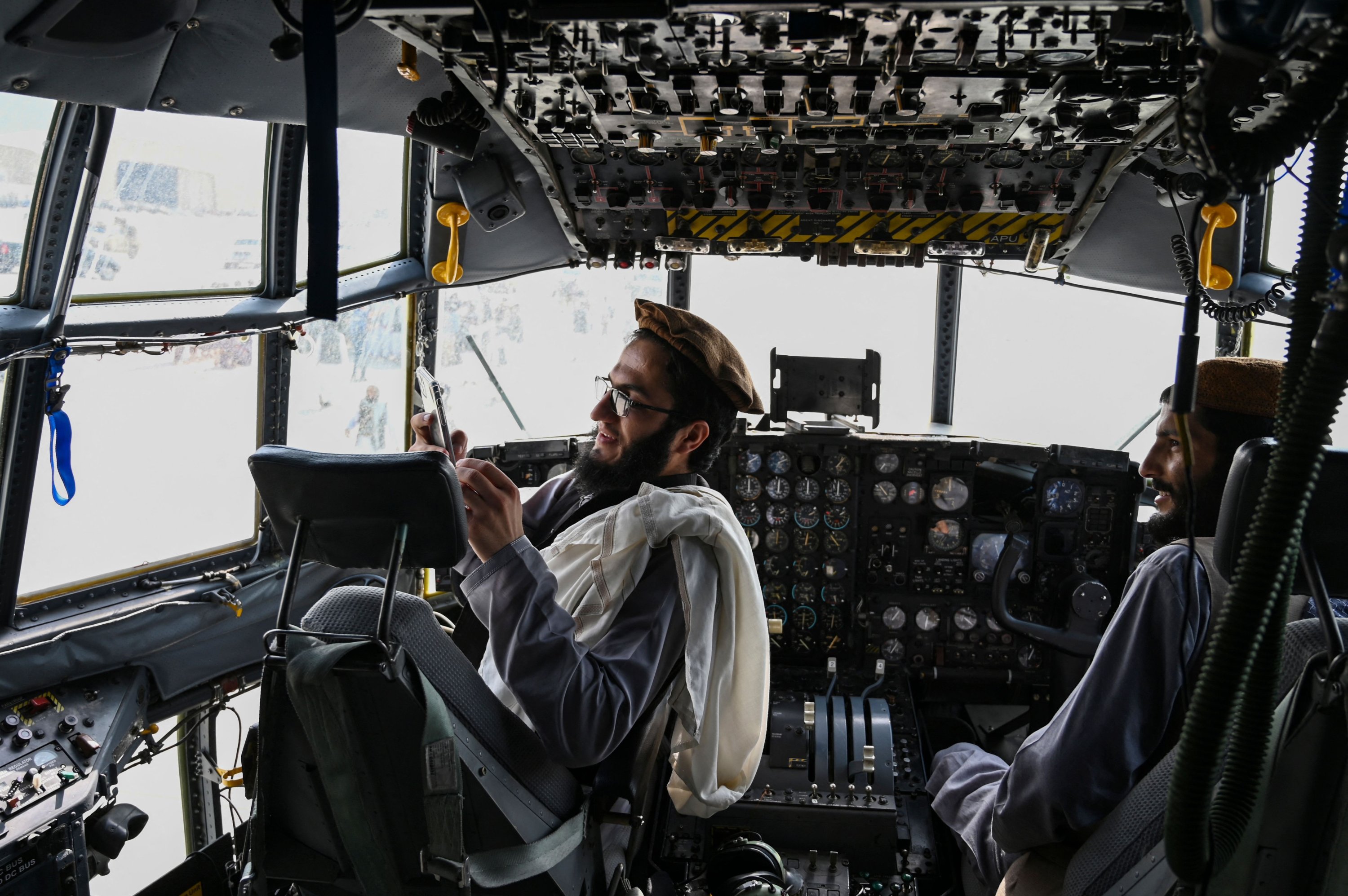 Taliban fighters sit in the cockpit of an Afghan Air Force aircraft at the airport in Kabul on Aug. 31, 2021, after the U.S. pulled all its troops out of the country to end a brutal 20-year war. (AFP Photo)