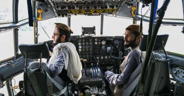 Taliban fighters sit in the cockpit of an Afghan Air Force aircraft at the airport in Kabul, Afghanistan, Aug. 31, 2021. (AFP Photo)