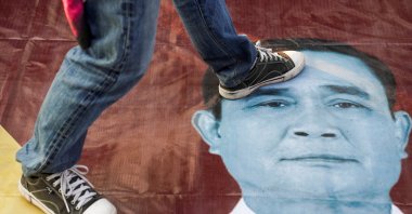 A protester steps on an image of Thailand's Prime Minister Prayuth Chan-ocha during a rally after he and nine ministers survived no-confidence debates, outside parliament in Bangkok, Thailand, Feb. 20, 2021. (Reuters File Photo)