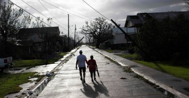 A couple walks down the street while holding hands after Hurricane Ida made landfall, Montegut, Louisiana, U.S., Aug. 30, 2021. (AFP Photo)