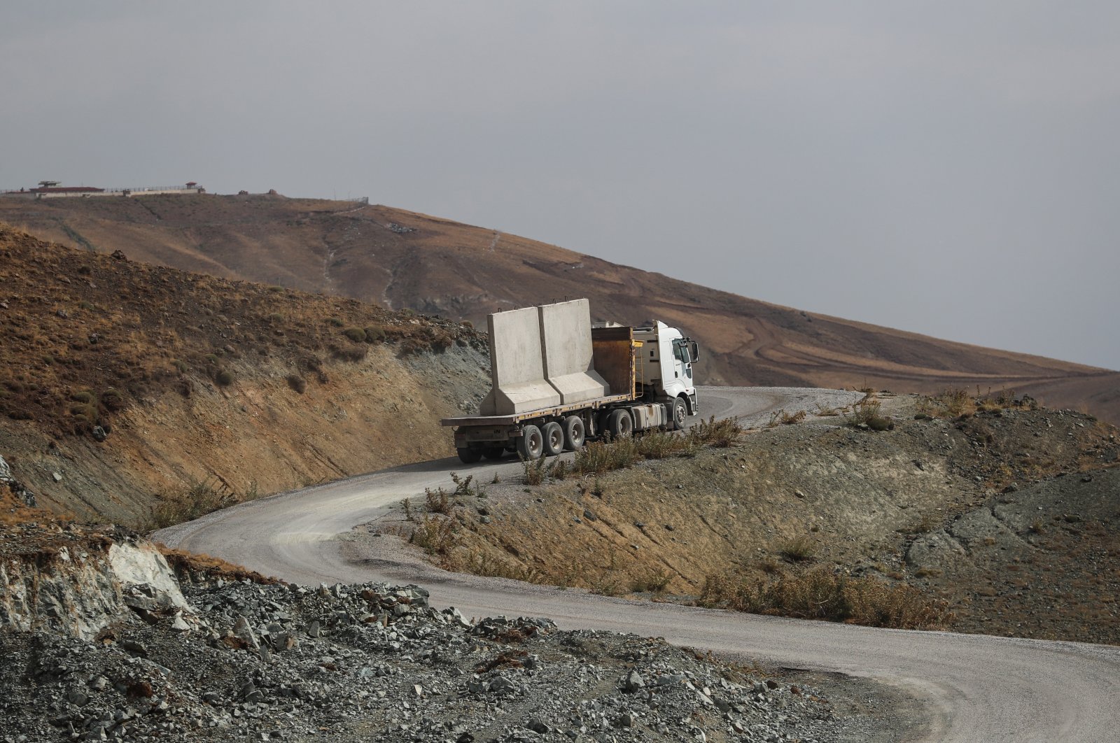 A truck carries modular concrete wall parts at the Turkey-Iran border line in Van city, Turkey, Aug. 24 2021. (EPA Photo)