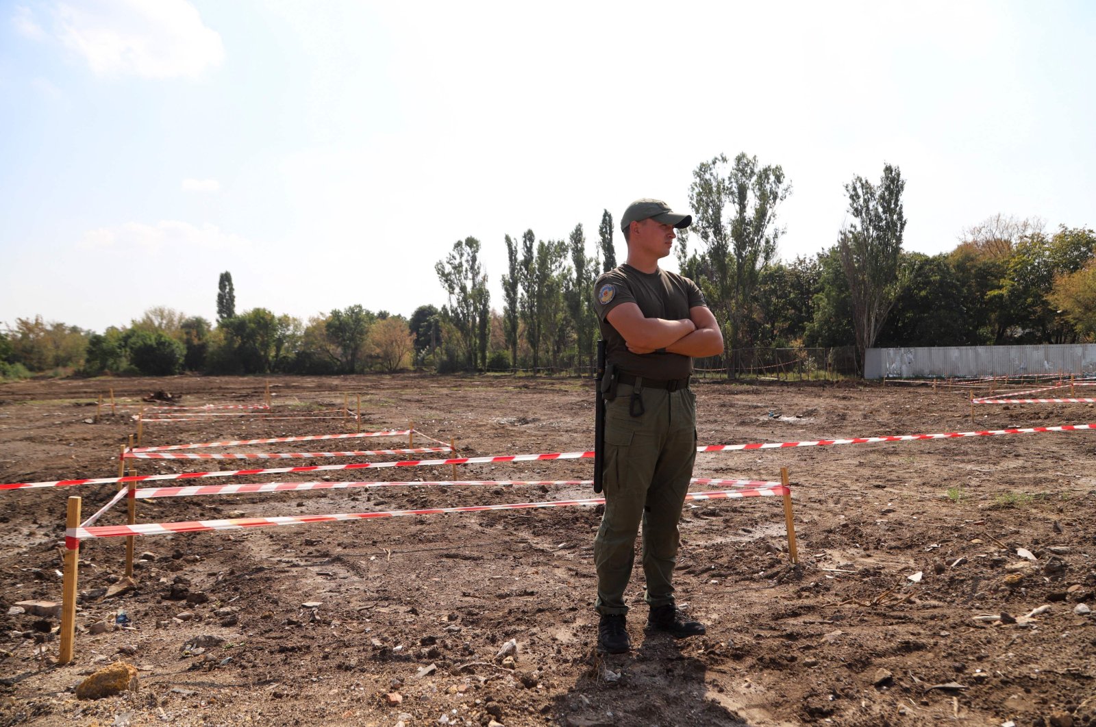 A security person stands guard at the mass graves site discovered on an abandoned area near the city airport where until recently was a dump in Odessa, Ukraine, Aug. 30, 2021. (AFP Photo)
