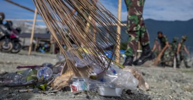 Indonesian soldiers pick up plastic waste scattered in the Talise Beach area, Palu, Central Sulawesi Province, Indonesia on July 23, 2021. (NurPhoto via Getty Images)