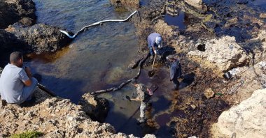 A handout picture released by the official Syrian Arab News Agency (SANA) shows people cleaning Syria's Mediterranean coast following an oil leak from the Baniyas power plant, Aug. 31, 2021. (AFP Photo)