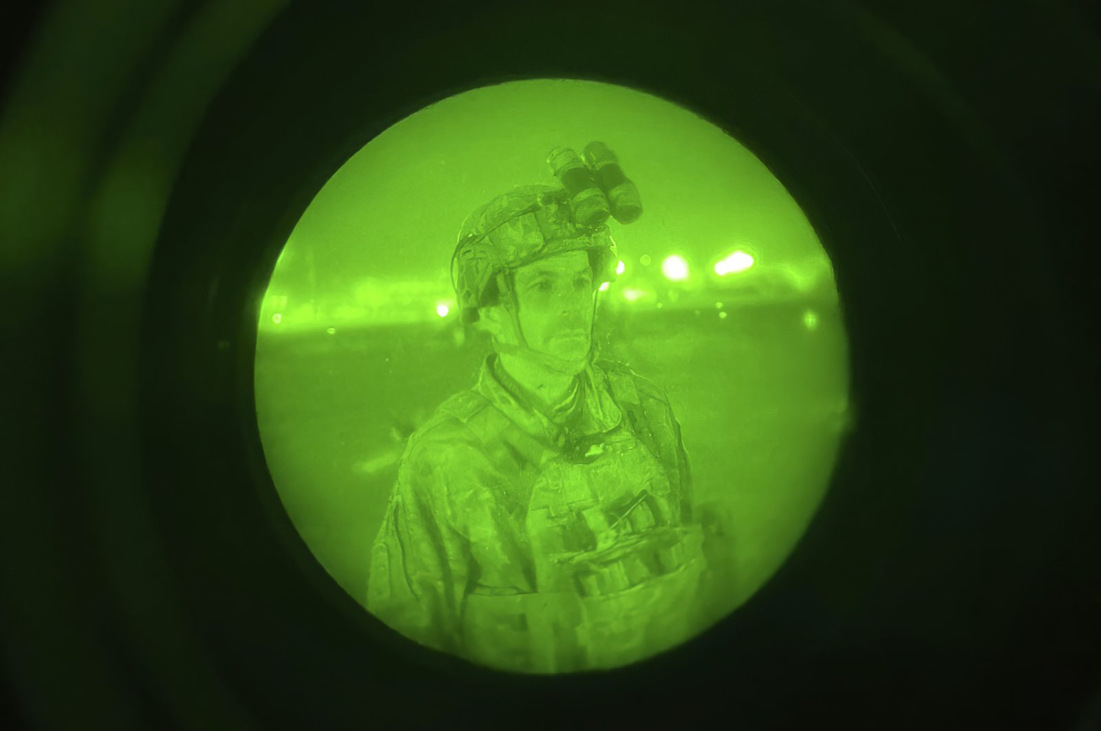 In this image made through a night vision scope and provided by the U.S. Army, Maj. Gen. Chris Donahue, commander of the U.S. Army 82nd Airborne Division, XVIII Airborne Corps, prepares to board a C-17 cargo plane at Kabul Hamid Karzai International Airport, Afghanistan, Aug. 30, 2021, as the final American service member to depart Afghanistan. (Master Sgt. Alexander Burnett/U.S. Army via AP)