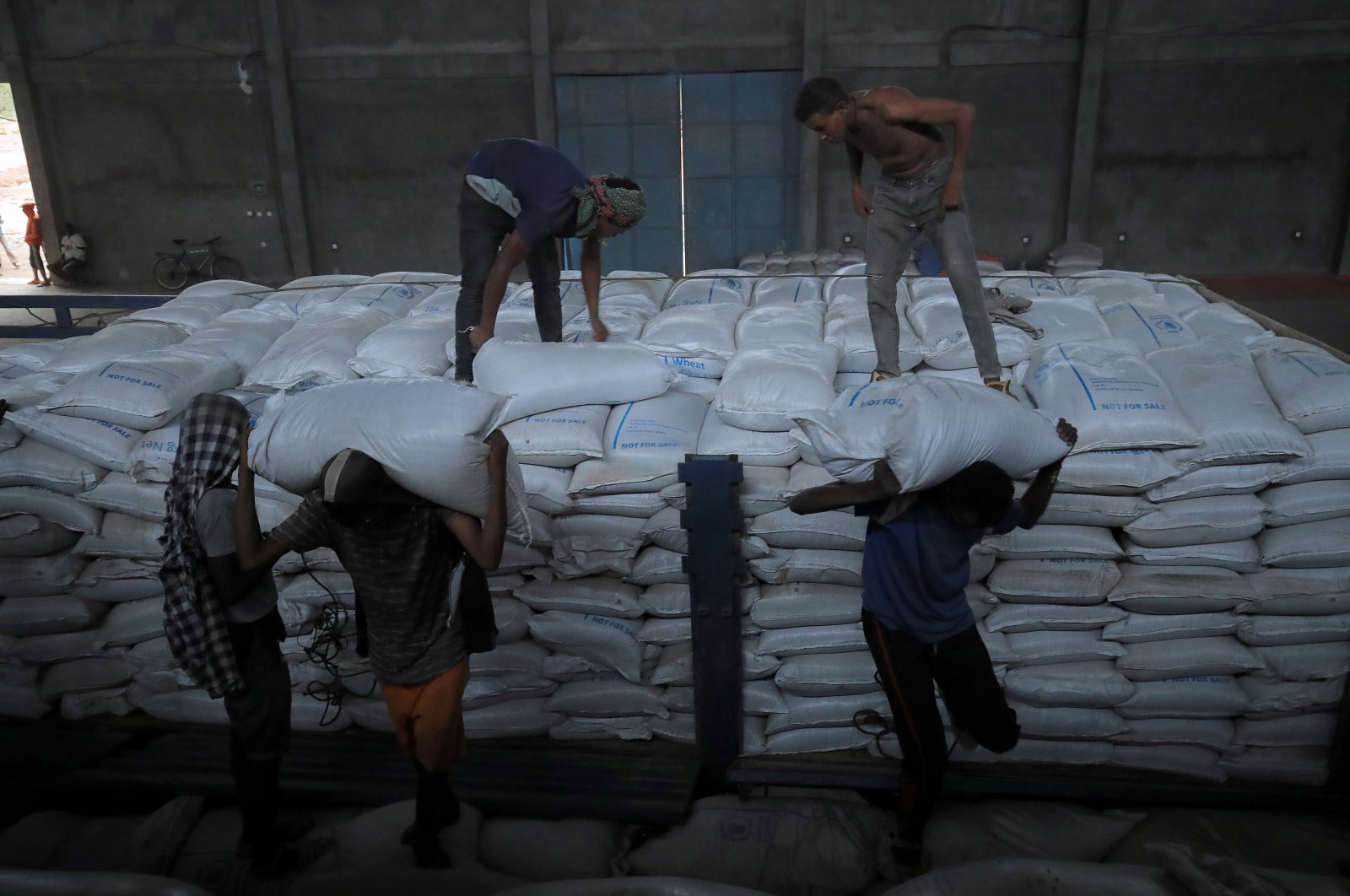 Ethiopian porters unload food aid bound for victims of war at a checkpoint leading to Tigray in Mai Tsebri town, Ethiopia, June 26, 2021. (Reuters Photo)