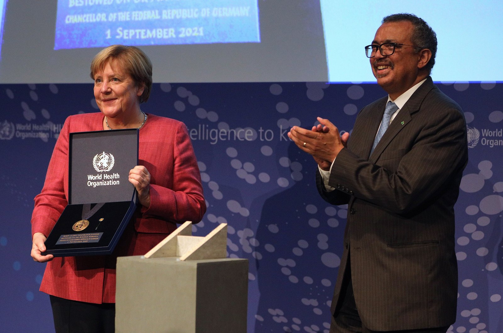 WHO Director-General Tedros Adhanom Ghebreyesus (R) honors German Chancellor Angela Merkel (L) during the inauguration ceremony of the new 'WHO Hub for Pandemic and Epidemic Intelligence' in Berlin, Germany, Sept. 1, 2021. (EPA Photo)